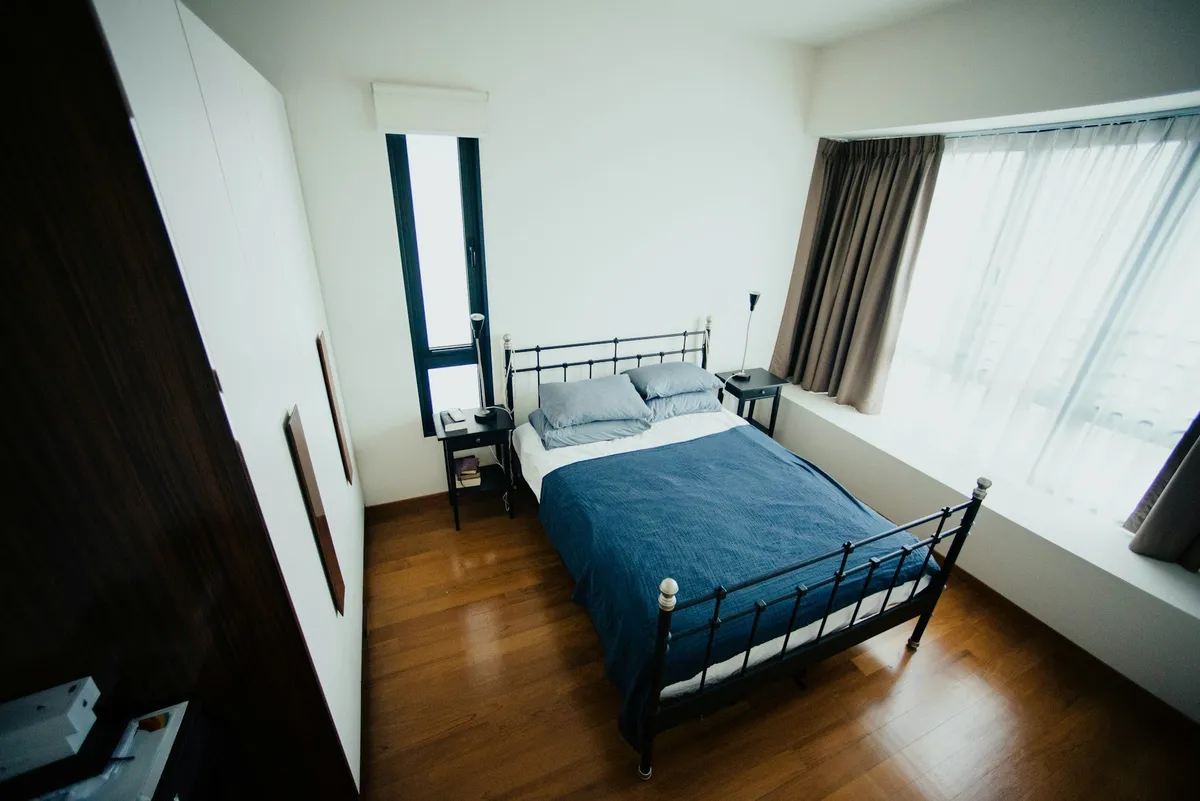 Einzelzimmer mit Bett, Fenster und Parkettboden
