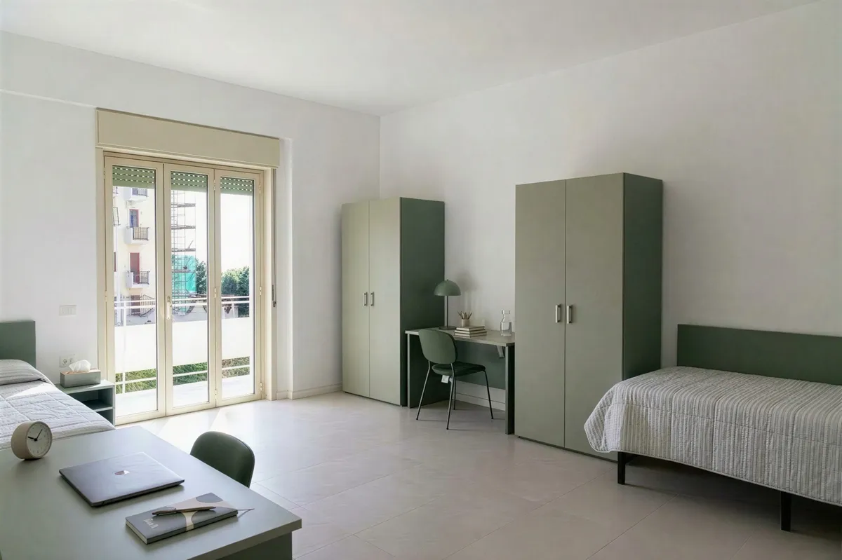 Habitación doble con dos camas, dos armarios, escritorios y puerta ventana al balcón