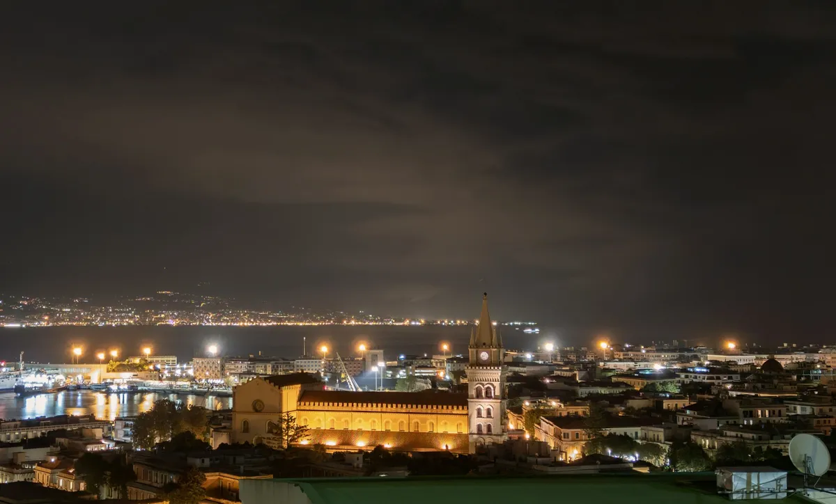 Messina am Abend, mit dem beleuchteten Dom und der Meerenge im Hintergrund