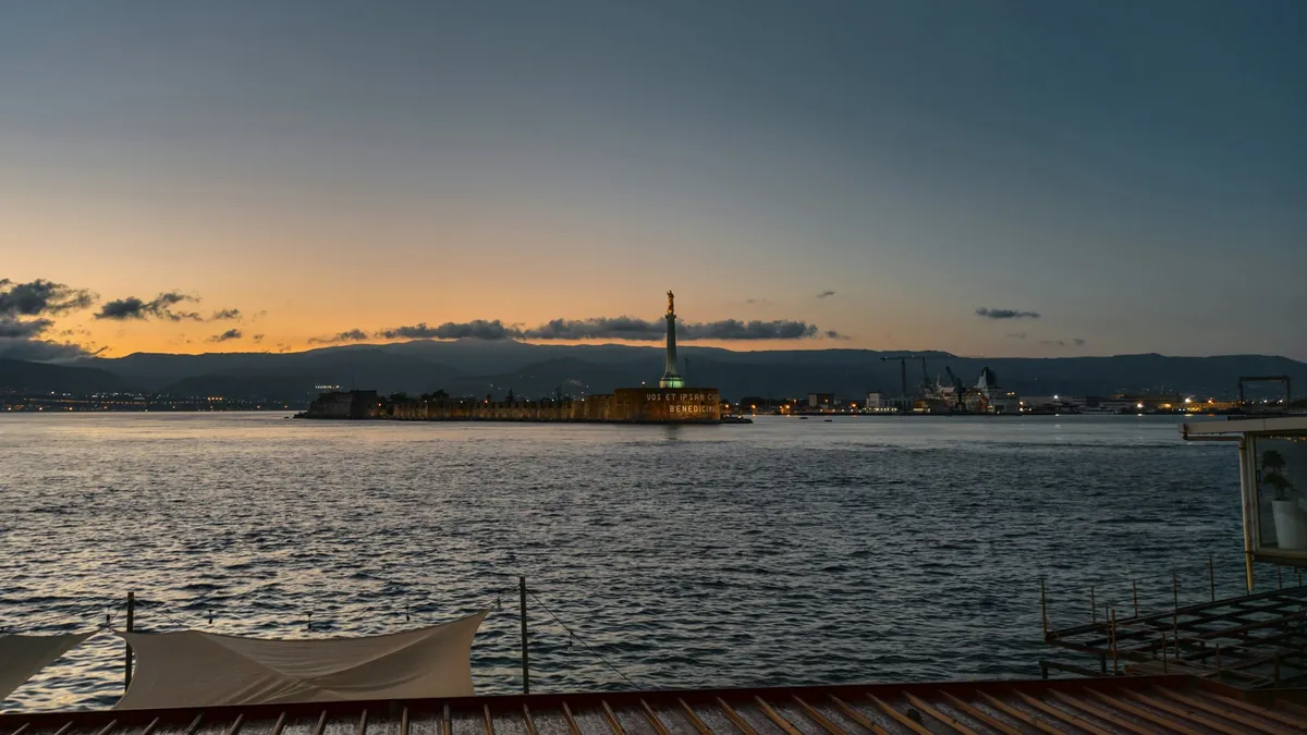 Der Hafen von Messina bei Sonnenuntergang mit der Madonnina-Statue